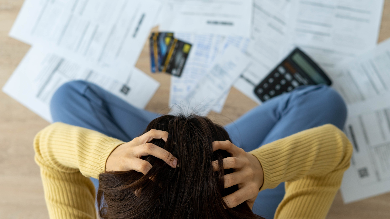 A woman stressed reading energy bills with her hands on her head showing the effect fuel poverty can have on mental health.