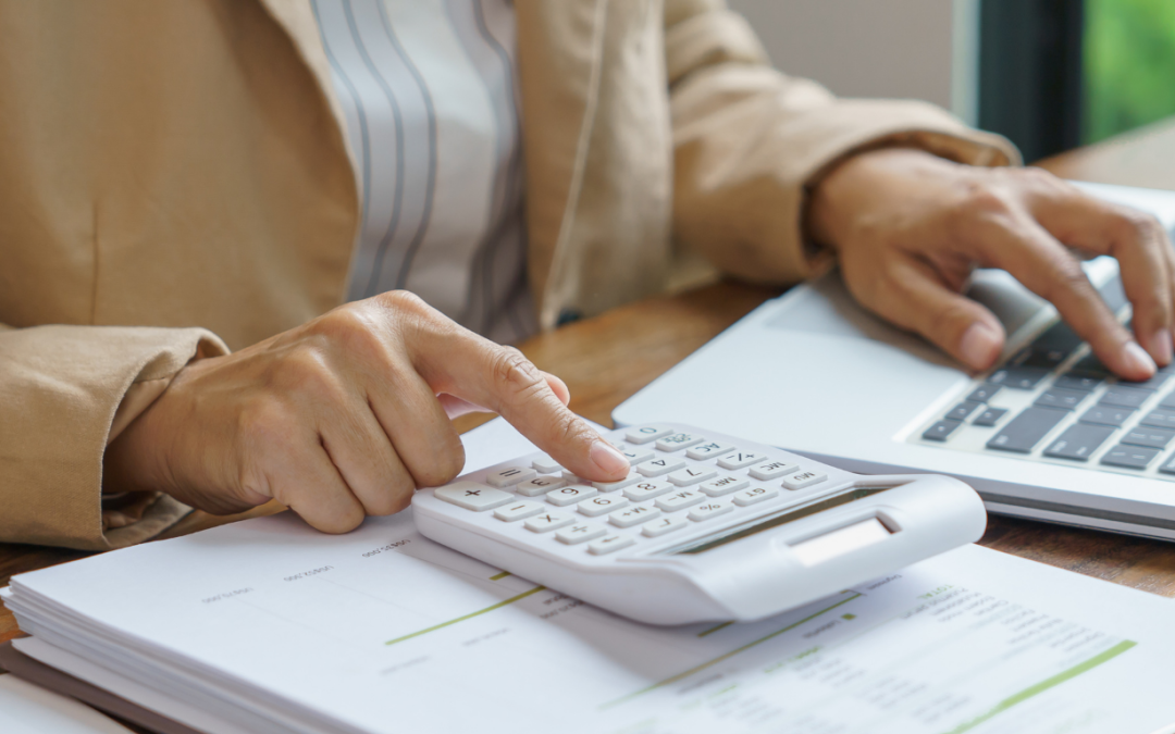 Person using calculator and laptop illustrating energy savings.